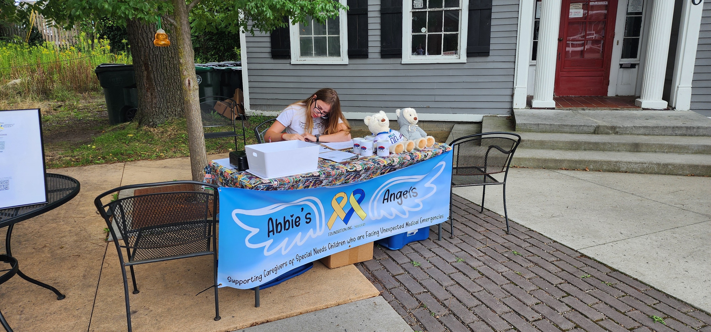 Danielle at Abbie's Angels ice cream social table with blue banner